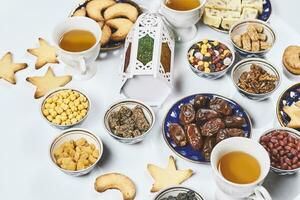 Iftar foods on white table. Traditional middle-eastern lunch with cookies and sweets photo