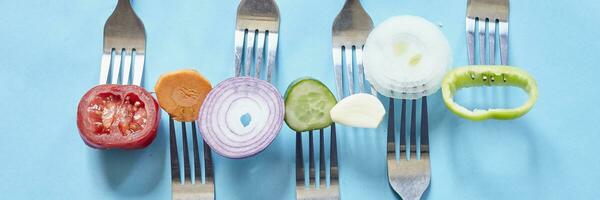 Sliced pieces of fresh vegetables on the forks photo