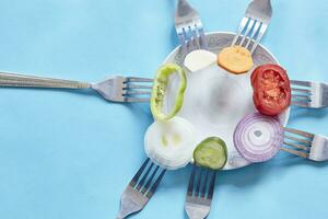 Sliced pieces of fresh vegetables on the forks photo