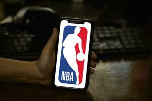 Hand hold mobile phone with NBA logo photo