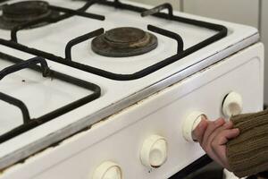 Woman checking gas, trying to turn on gas on old gas stove photo