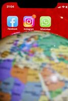 Miniature globe and social media icons on phone display photo