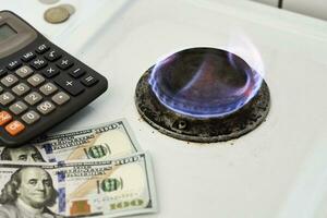 Burning gas stove burner, calculator and money photo