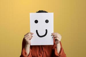 Woman holds a paper with drawn fake smile photo