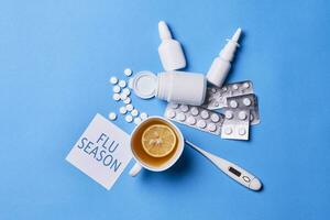 Flu and cold season. Lemon tea, medical pills and remedies photo