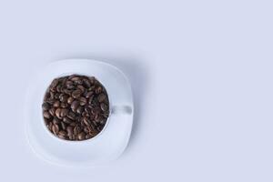 A cup filled with raw coffee beans photo
