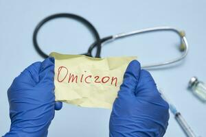 Doctor hand holds a piece of rumpled paper with Omicron text photo
