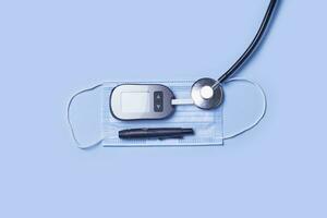 Blood glucose monitor kit diabetes testing kit on blue photo