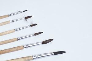 Various size painting brushes on white photo