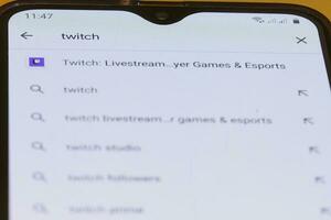 Searching and downloading Twitch application to smartphone photo