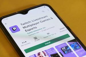 Searching and downloading Twitch application to smartphone photo