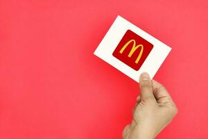 mano sostiene un tarjeta con McDonalds logo foto