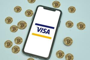 visa logo aplicación en móvil teléfono pantalla y bitcoins criptomoneda foto