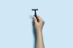 Hand holds a multiple use shaving razor photo