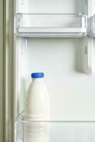 un botella de agrio crema en refrigerador foto