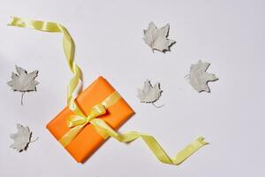 Gift boxes and fall leaves on white photo
