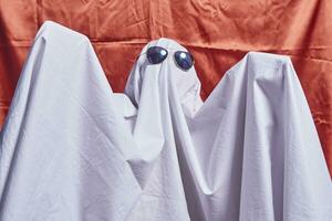 White ghost on orange. Halloween holiday photo