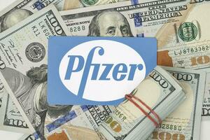 Pile of us dollars and Pfizer card photo