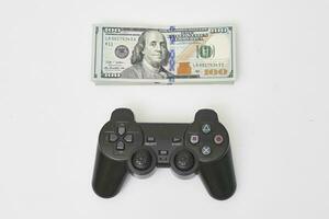 juego consola controlador y pila de dinero foto