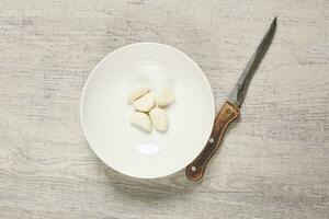 Cleaning organic garlic on wooden board photo