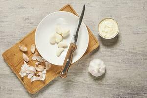 Cleaning organic garlic on cutting board photo