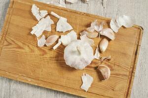 Cleaning organic garlic on cutting board photo