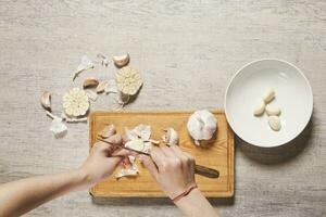 Cleaning organic garlic on cutting board photo