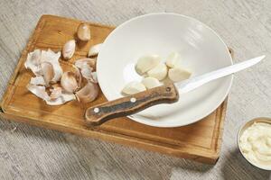 Cleaning organic garlic on cutting board photo