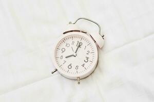 alarma reloj en blanco cama foto