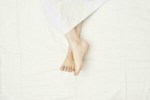 Sleeping woman feet on bed photo