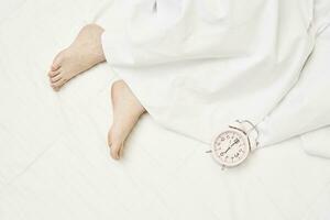 A clock and feet of a sleeping woman photo