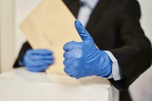 A person in medical gloves voting photo