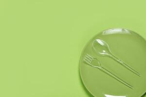 verde plato y el plastico tenedor con cuchara foto