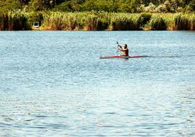 Dnipro, Ukraine - 06.20.2023 Technique of rowing of a single athlete on a kayak. Paddle splash motion. photo