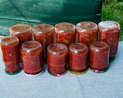 Traditional Hungarian homemade lecho in glass jars. Preserved tomatoes and peppers with spices. photo