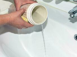 Female hands are washing the flask for water filters. The process of replacing cartridges of a multi-stage water filter. photo