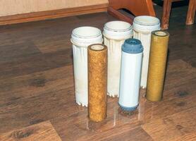 Used water filters with traces of dirt, clay and impurities. Replacing multi-stage water filter cartridges. photo