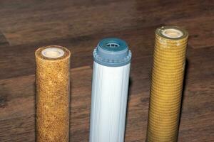 Used water filters with traces of dirt, clay and impurities. Replacing multi-stage water filter cartridges. photo