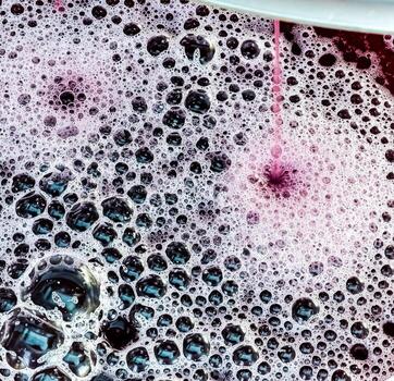 The process of making homemade grape wine. The operation of a hydraulic press to obtain grape juice for fermentation. Close-up of freshly squeezed grape juice photo