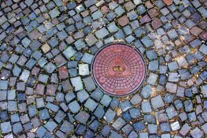 Manhole cover of the gas pipeline system. A massive metal hatch for access to city communications in the pavement. photo