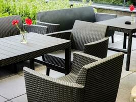 Table and chairs on an outdoor patio after the rain. There are no people in the cozy bar. photo