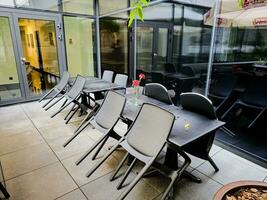 Table and chairs on an outdoor patio after the rain. There are no people in the cozy bar. photo