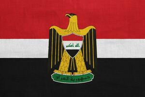 bandera y Saco de brazos de república de Irak en un texturizado antecedentes. concepto collage. foto