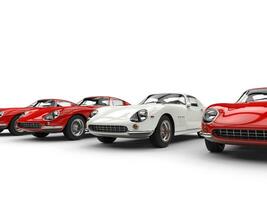 Vintage sports cars - white stands out in a row of red cars - isolated on white background photo