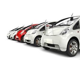 Compact white electric cars in a row - red stands out photo