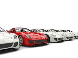 Red sports car stands out in a row of white generic cars photo