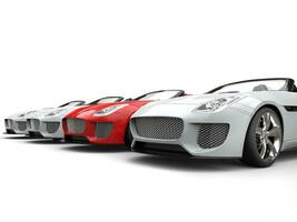 Red sports car stands out amongs white sports cars photo