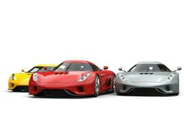 Red, yellow and grey supercars closely racing photo