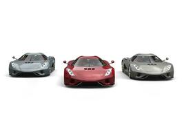 Two gray and one red metallic supercars - front view photo