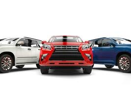 Awesome red modern SUV with white and blue cars on each side photo